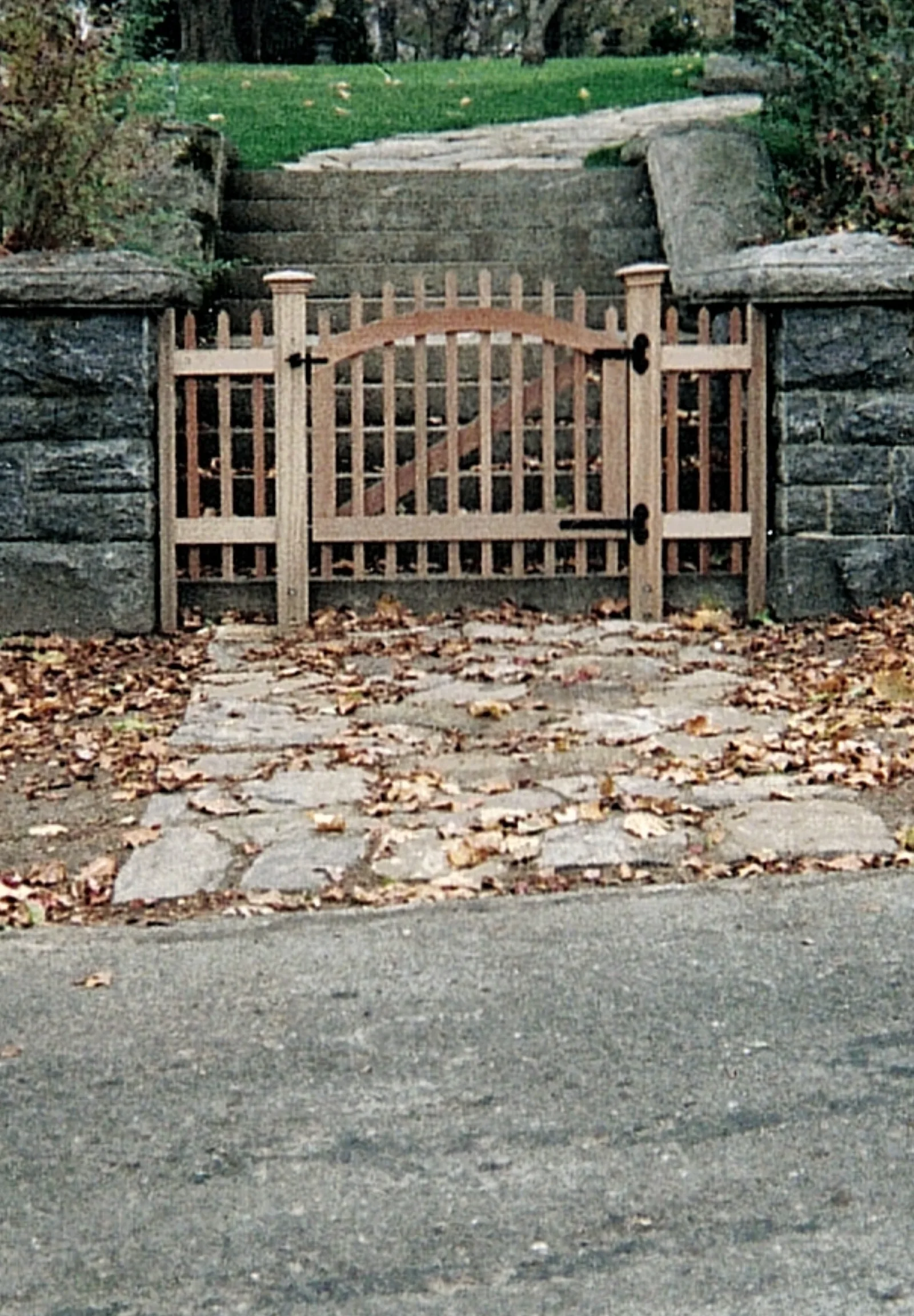 Arched Cedar Walk Gate at Stone Wall project by Excalibur Fence and Iron Works