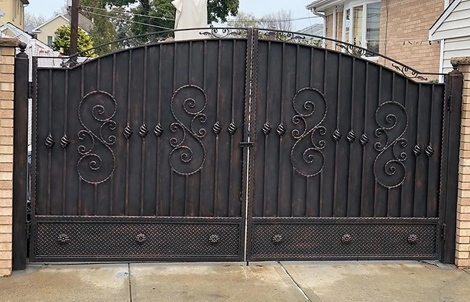 Custom wrought iron driveway gate with decorative scrollwork installed at a Fairfield County home