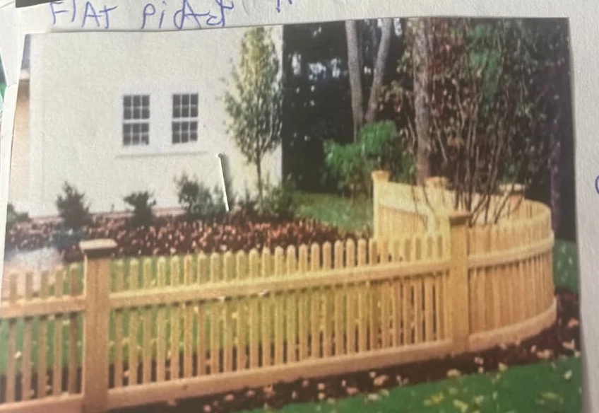 Custom curved cedar picket fence following a landscaped yard