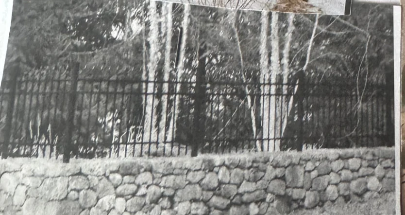 Black iron fence installed along a fieldstone wall
