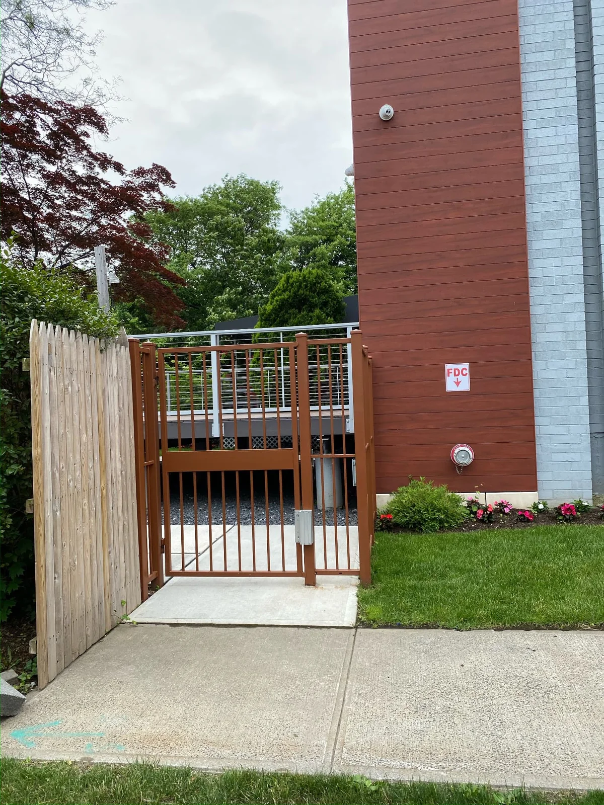 Brown powder-coated metal walk gate beside a commercial building