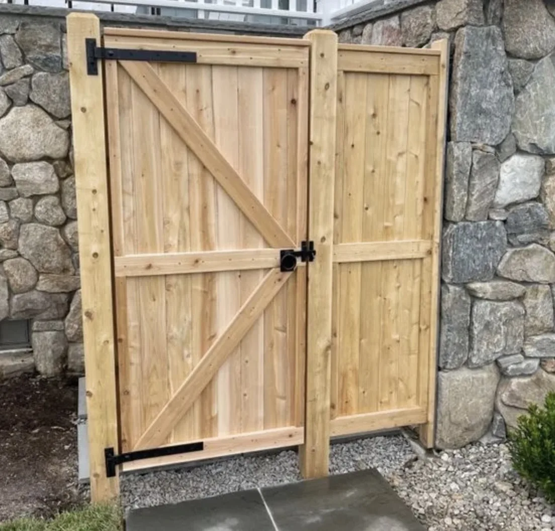Cedar Double Gate at Stone Wall project by Excalibur Fence and Iron Works