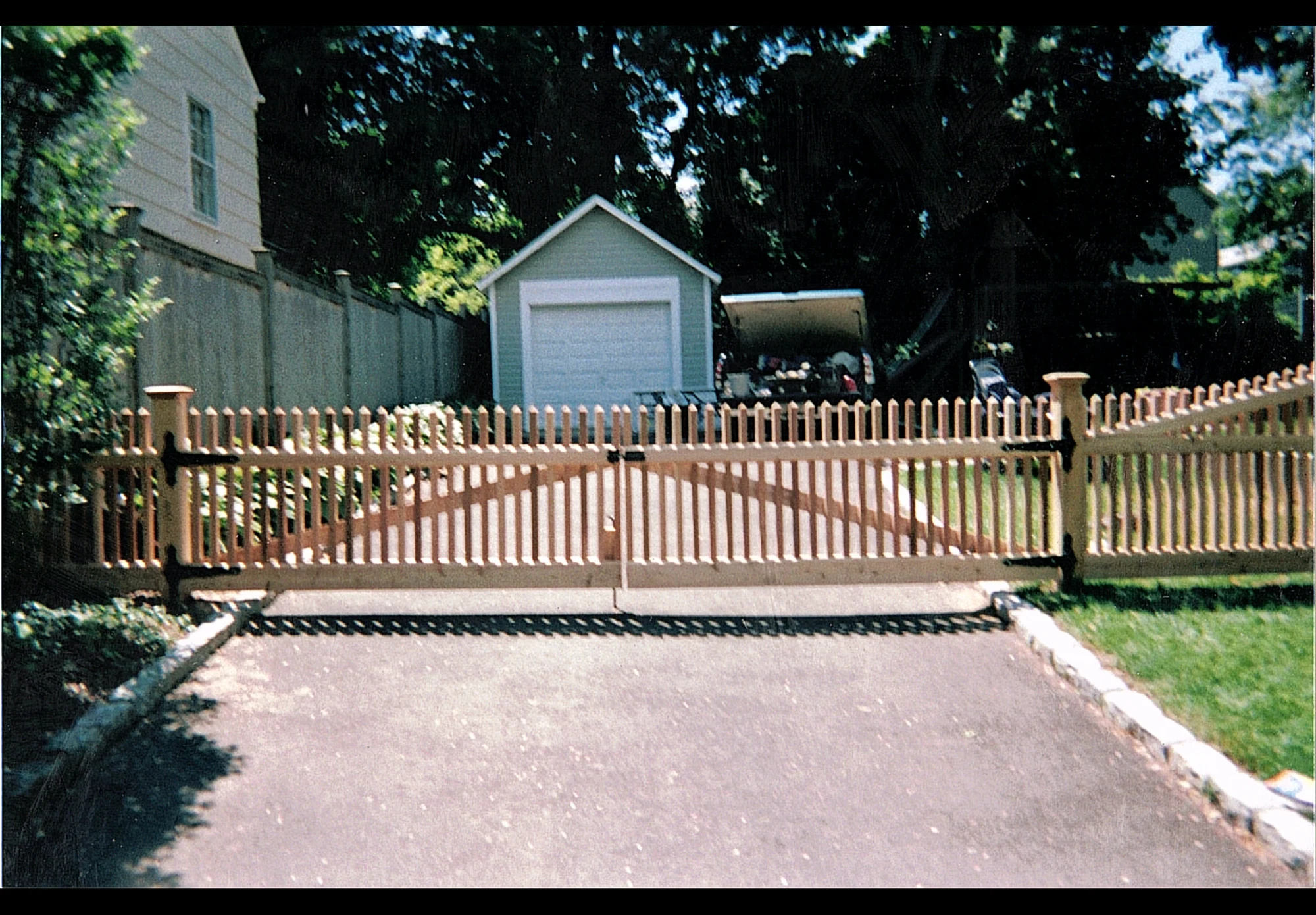 Cedar spindle driveway gate across a residential driveway