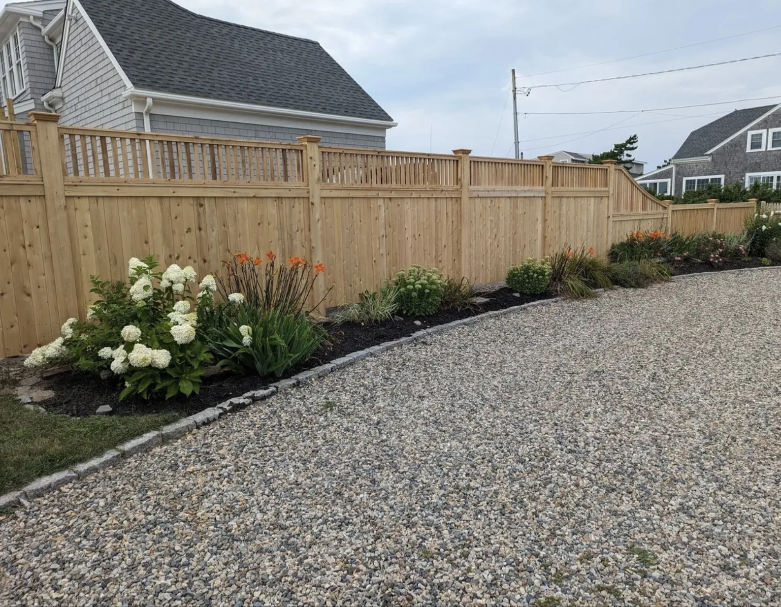 Cedar Fence with Spindle Top Along Driveway project by Excalibur Fence and Iron Works